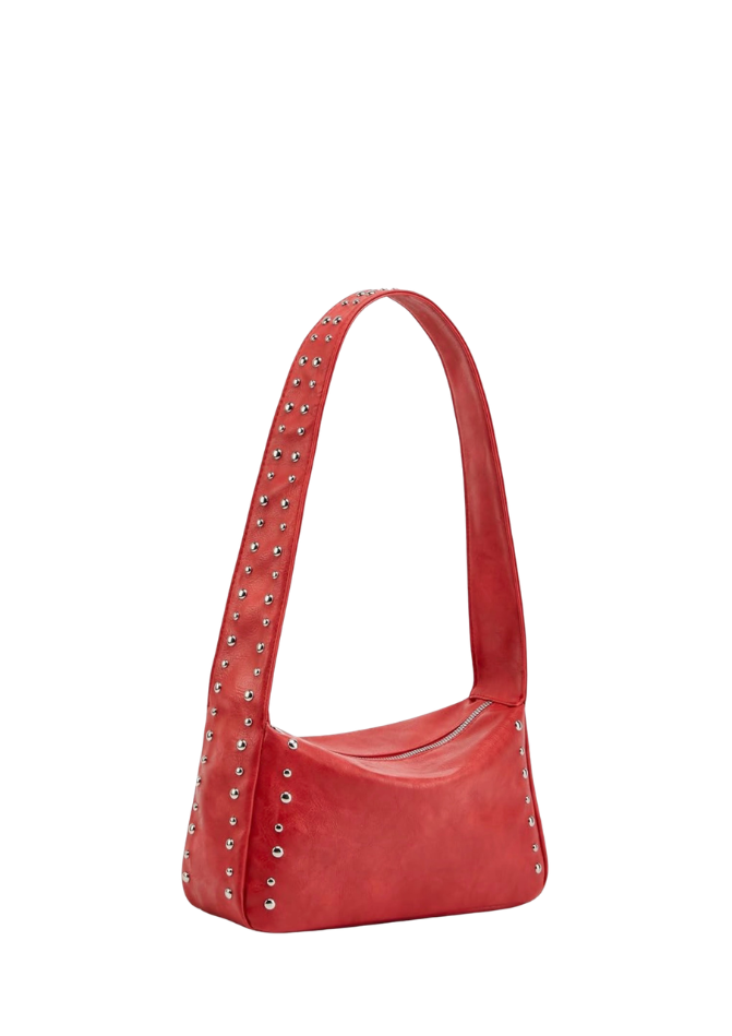 A red faux-leather shoulder bag with silver metal studs and grommets along the strap and sides, shown on a plain white background.